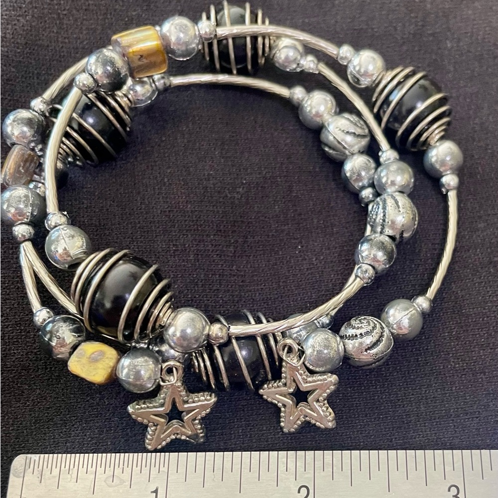 Bracelet with stretch. Black and silver with star charms adjustable to any size.